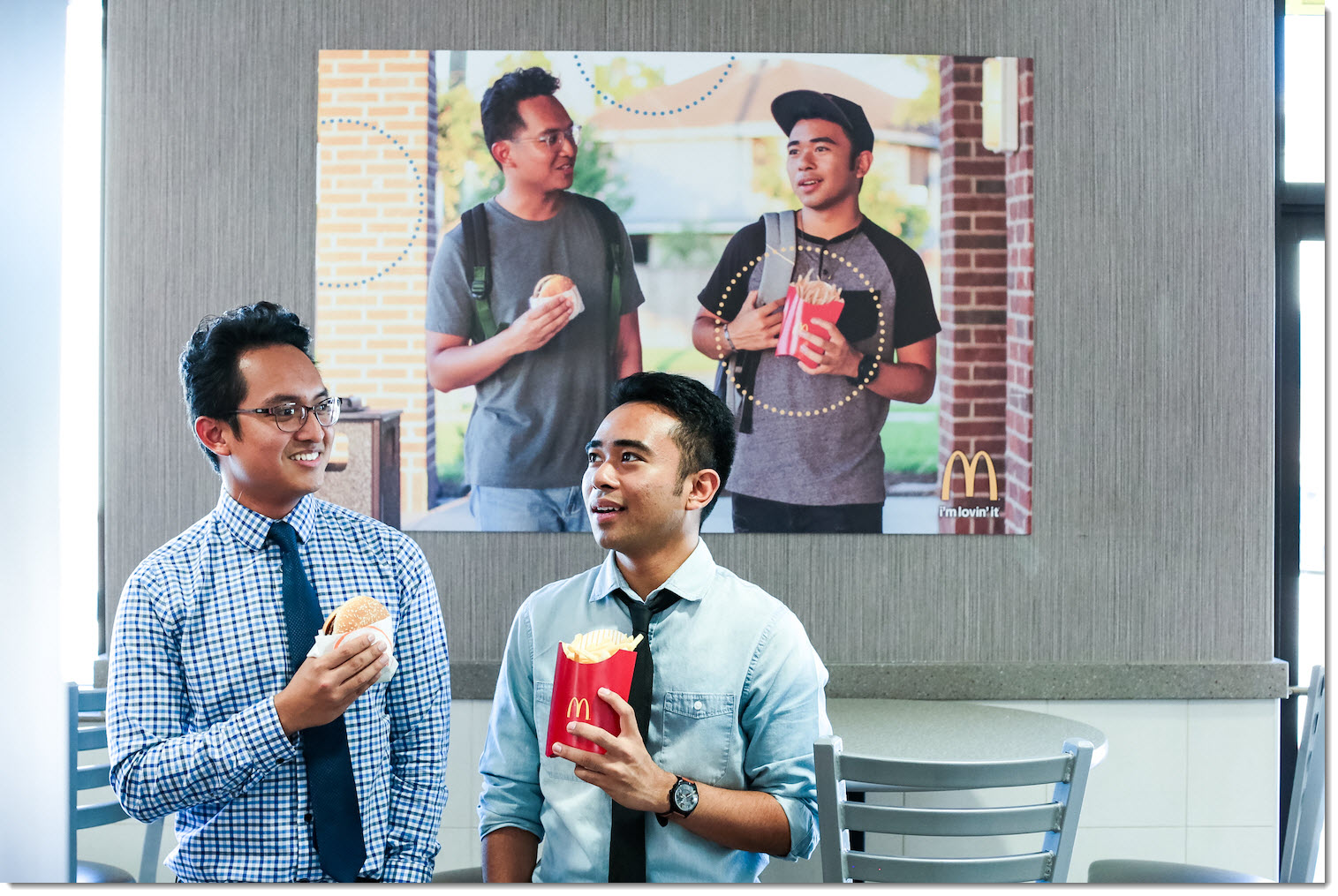 Christian and Jevh in working clothes posing in front of their poster